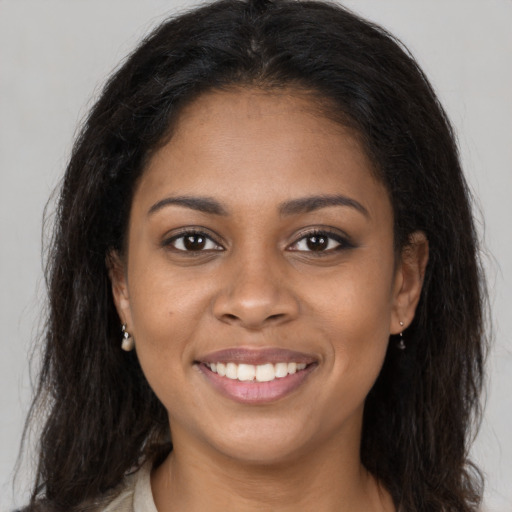Joyful black young-adult female with long  brown hair and brown eyes