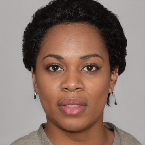 Joyful black young-adult female with short  black hair and brown eyes