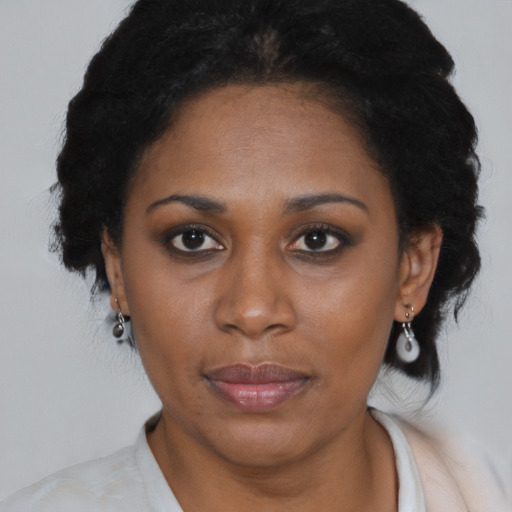 Joyful black adult female with medium  black hair and brown eyes
