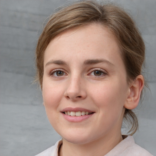 Joyful white young-adult female with medium  brown hair and grey eyes