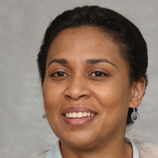 Joyful latino adult female with medium  brown hair and brown eyes