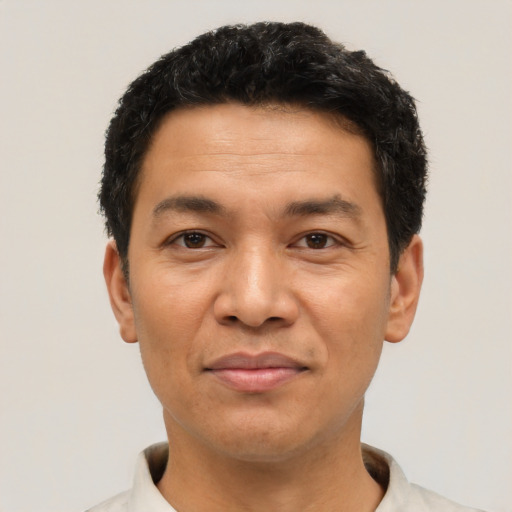 Joyful latino adult male with short  black hair and brown eyes