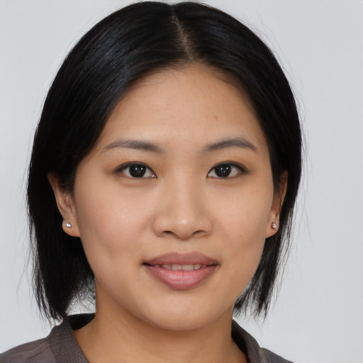 Joyful asian young-adult female with medium  black hair and brown eyes