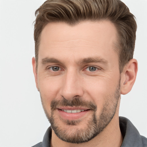 Joyful white adult male with short  brown hair and brown eyes