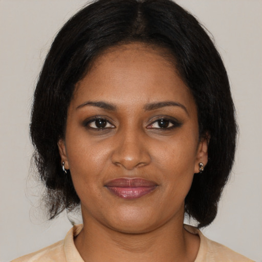 Joyful black adult female with medium  brown hair and brown eyes