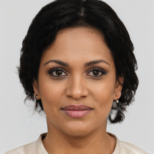 Joyful black young-adult female with medium  black hair and brown eyes