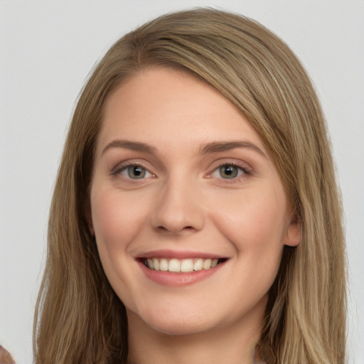 Joyful white young-adult female with long  brown hair and green eyes