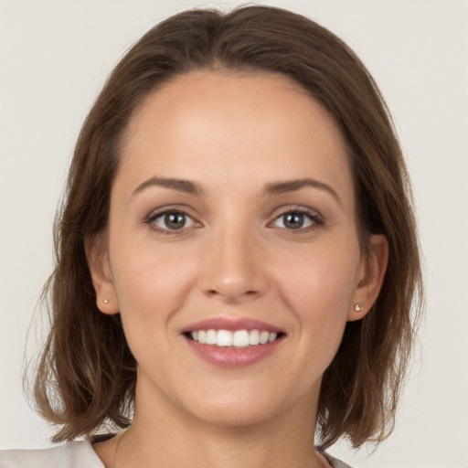 Joyful white young-adult female with long  brown hair and grey eyes