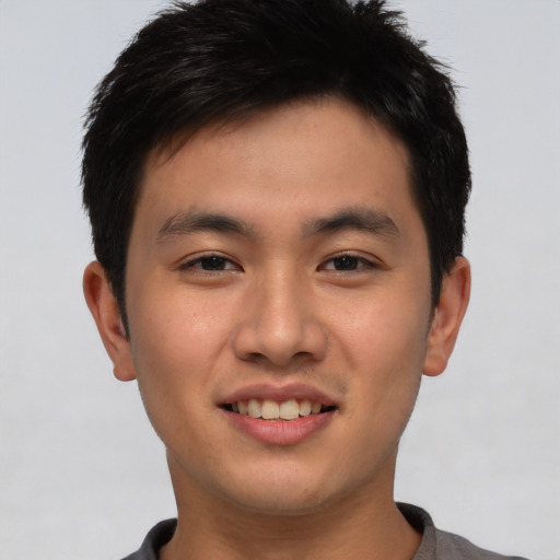 Joyful asian young-adult male with short  brown hair and brown eyes