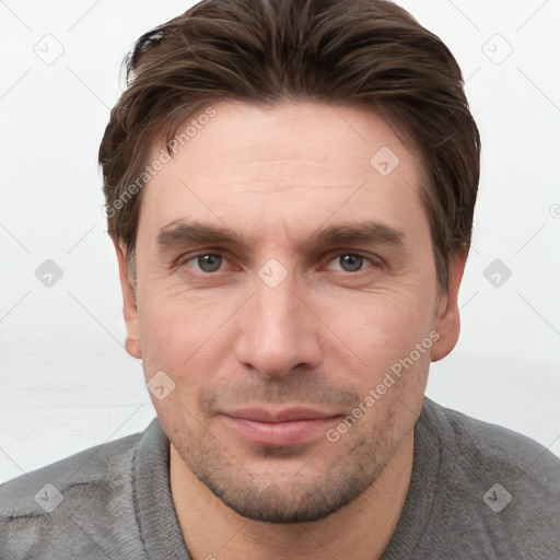 Joyful white young-adult male with short  brown hair and grey eyes