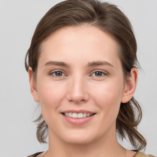 Joyful white young-adult female with medium  brown hair and grey eyes