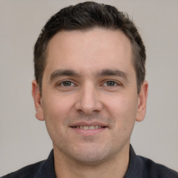 Joyful white young-adult male with short  brown hair and brown eyes