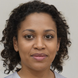 Joyful black adult female with medium  brown hair and brown eyes