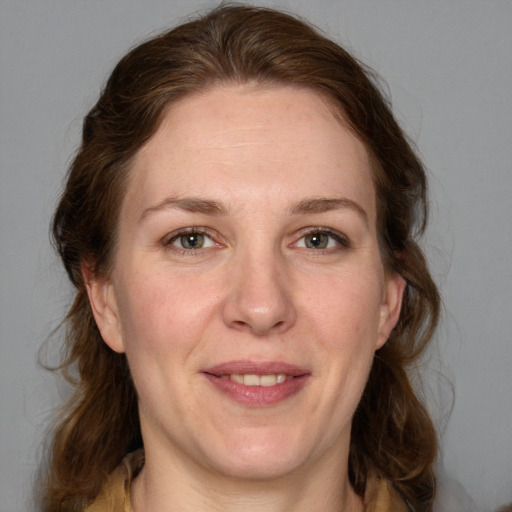 Joyful white adult female with medium  brown hair and grey eyes