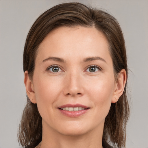 Joyful white young-adult female with medium  brown hair and grey eyes