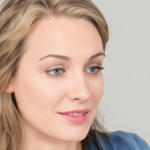 Joyful white young-adult female with long  brown hair and blue eyes