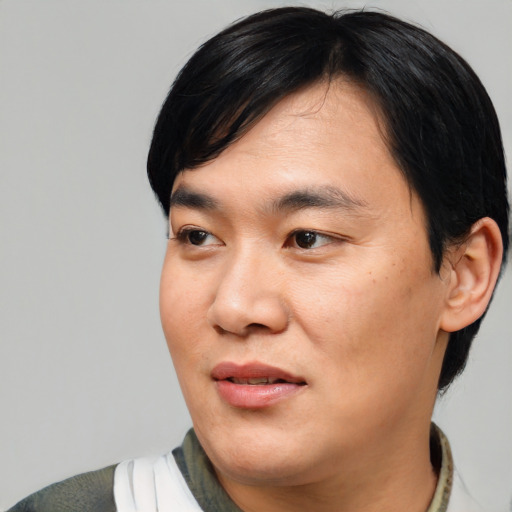 Joyful asian adult male with medium  black hair and brown eyes