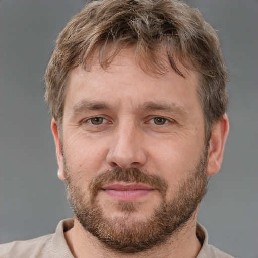 Joyful white adult male with short  brown hair and grey eyes