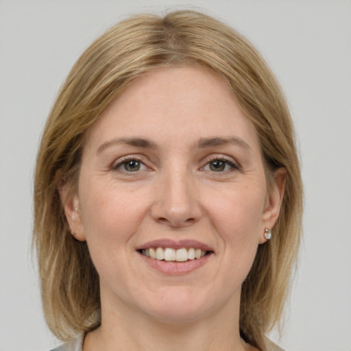 Joyful white adult female with medium  brown hair and grey eyes