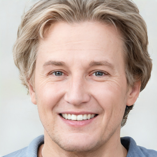 Joyful white adult male with short  brown hair and grey eyes