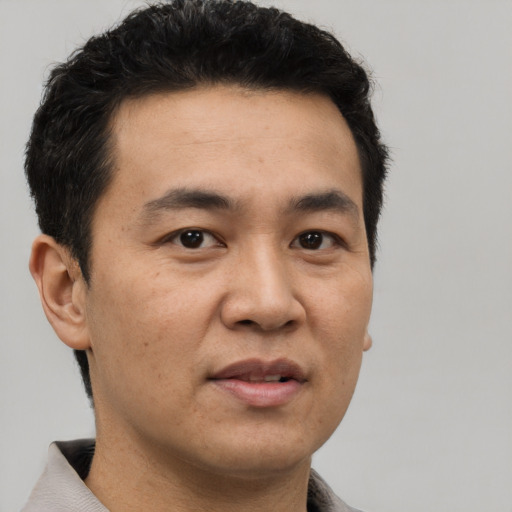 Joyful asian adult male with short  brown hair and brown eyes