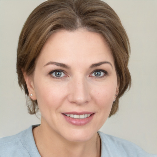 Joyful white adult female with medium  brown hair and grey eyes