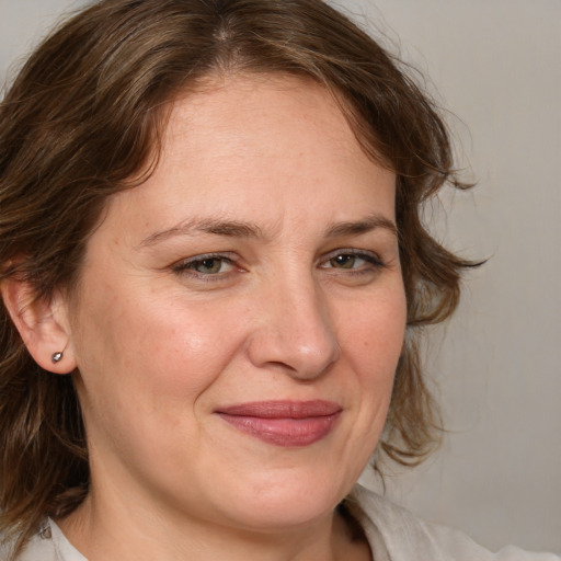 Joyful white adult female with medium  brown hair and blue eyes