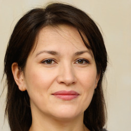 Joyful white adult female with medium  brown hair and brown eyes