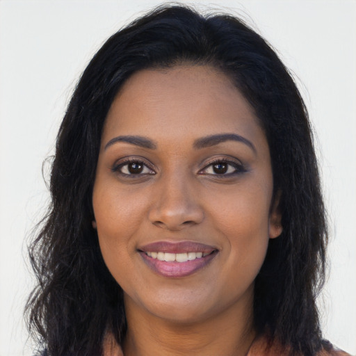 Joyful black young-adult female with long  brown hair and brown eyes