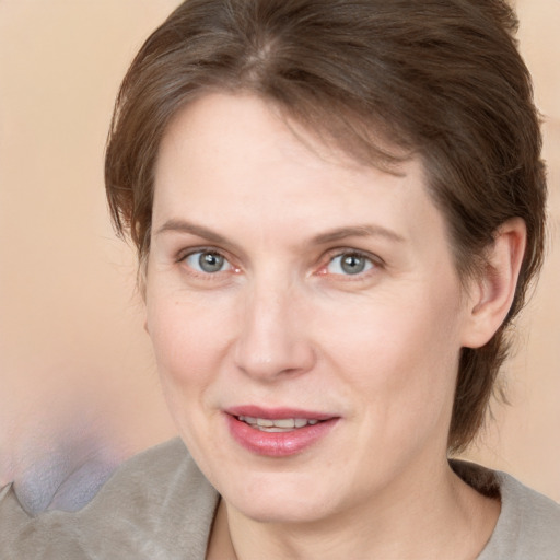 Joyful white adult female with medium  brown hair and grey eyes