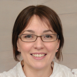 Joyful white young-adult female with medium  brown hair and blue eyes