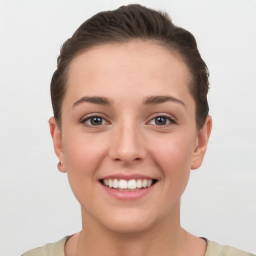 Joyful white young-adult female with short  brown hair and brown eyes