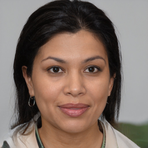 Joyful latino young-adult female with medium  brown hair and brown eyes