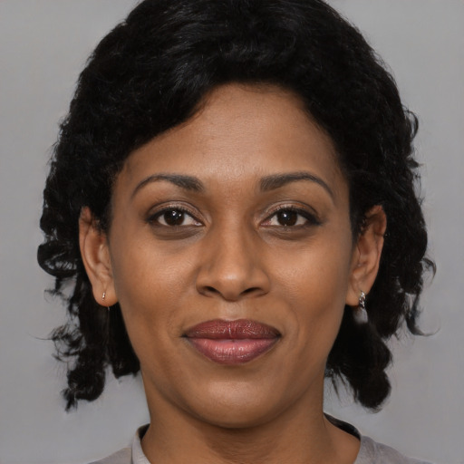 Joyful black adult female with medium  black hair and brown eyes