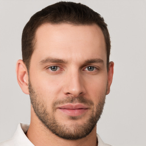 Joyful white young-adult male with short  brown hair and grey eyes