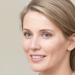 Joyful white young-adult female with long  brown hair and blue eyes