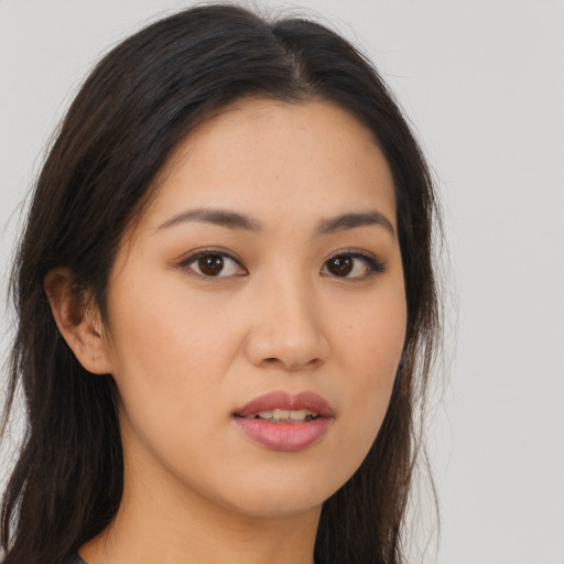 Joyful asian young-adult female with long  brown hair and brown eyes