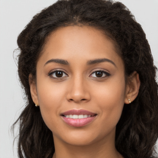 Joyful latino young-adult female with long  brown hair and brown eyes