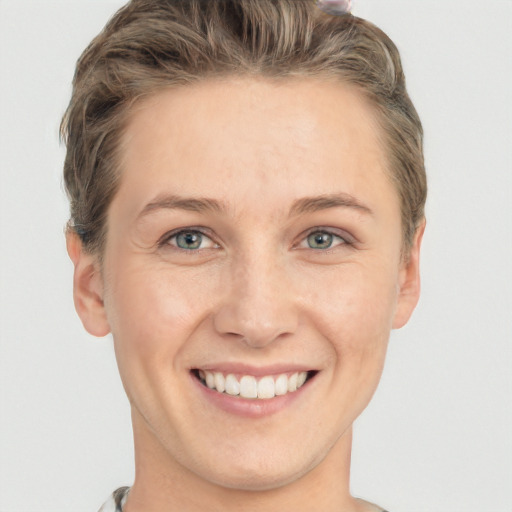 Joyful white young-adult female with short  brown hair and grey eyes