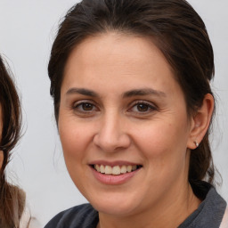 Joyful white adult female with medium  brown hair and brown eyes