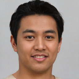 Joyful asian young-adult male with short  black hair and brown eyes