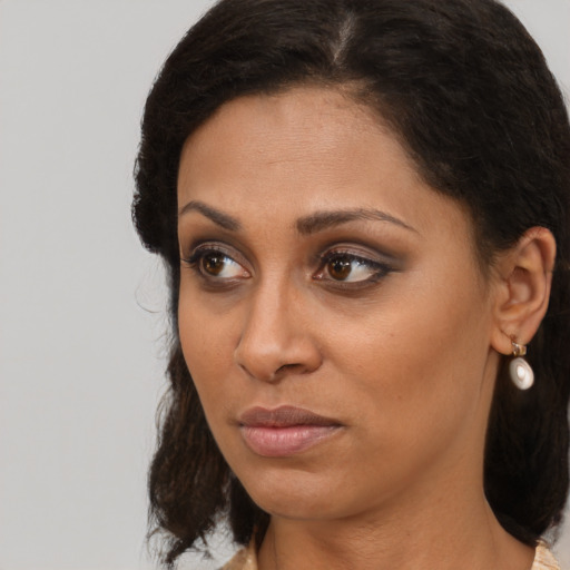 Neutral black young-adult female with medium  brown hair and brown eyes