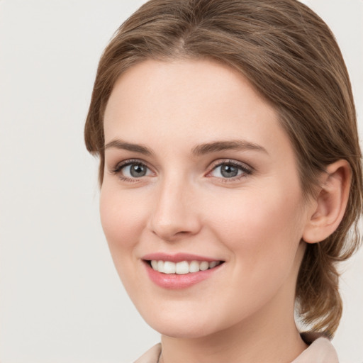 Joyful white young-adult female with medium  brown hair and green eyes