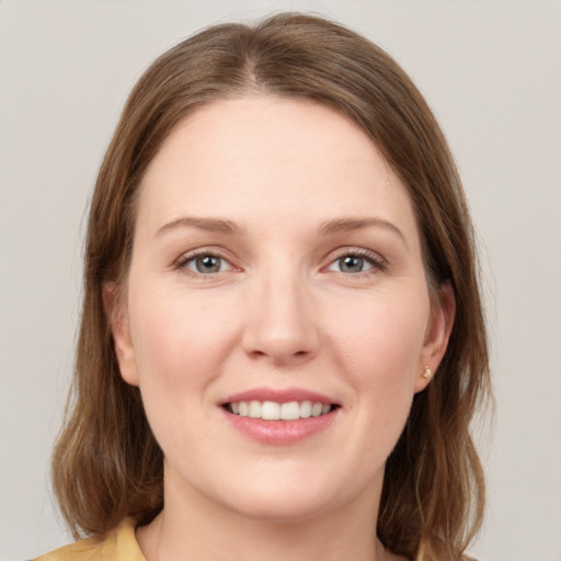 Joyful white young-adult female with medium  brown hair and grey eyes