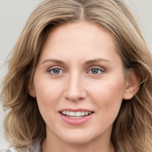 Joyful white young-adult female with long  brown hair and blue eyes