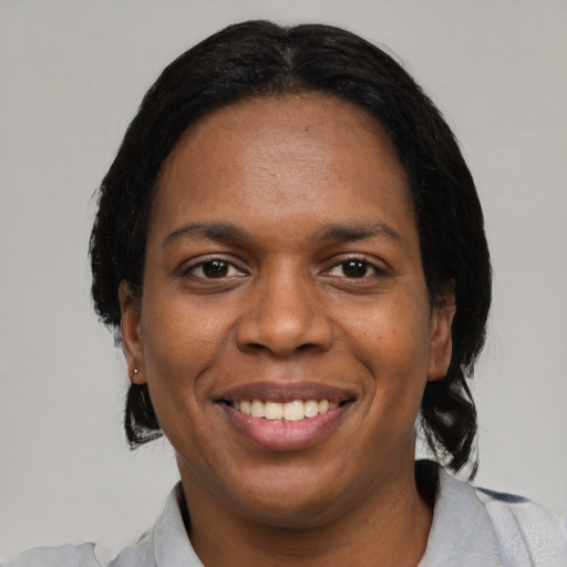 Joyful black young-adult female with medium  black hair and brown eyes
