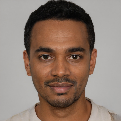 Joyful black young-adult male with short  black hair and brown eyes