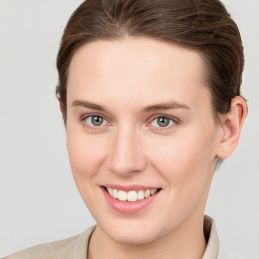 Joyful white young-adult female with short  brown hair and grey eyes