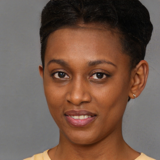 Joyful black young-adult female with short  brown hair and brown eyes