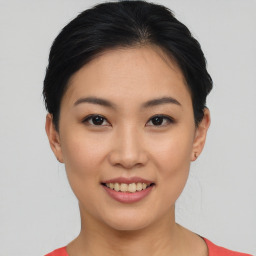 Joyful asian young-adult female with short  black hair and brown eyes